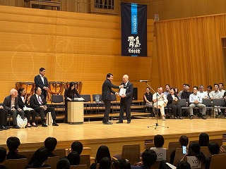 堤音楽監督に記念品を贈呈する様子
