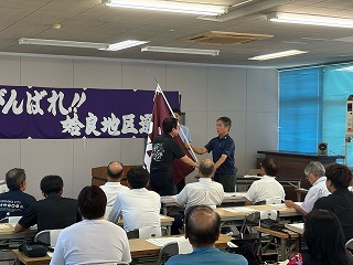 チーム旗を代表者に手渡す様子